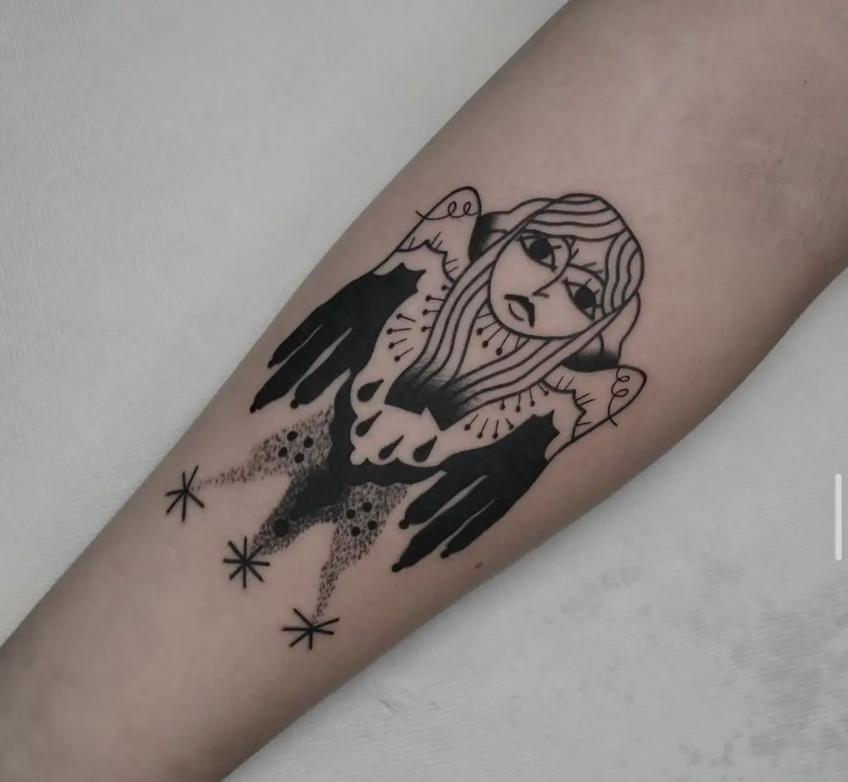 Ein Black work Tattoo eines Engels, mit langen Haaren, dunklen Flügeln und drei Sternen am unteren Rand